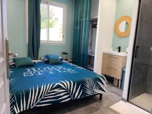 a bedroom with a blue bed and a window at La villa Selah **** in Saint-Louis