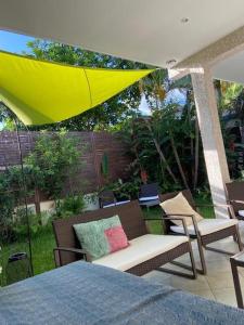 eine Terrasse mit 2 Stühlen und einem Sonnenschirm in der Unterkunft La villa Selah **** in Saint-Louis