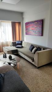 - un salon avec un canapé et une table dans l'établissement Praxitelous CityCenter Modern Apartments by Aesthetic Living, à Athènes