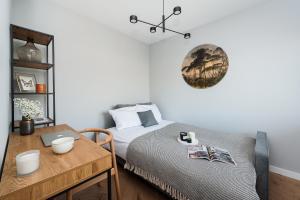 sypialnia z łóżkiem i stołem z laptopem w obiekcie Zen Apartment by LoftAffair w Krakowie