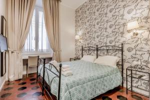 Schlafzimmer mit einem Bett mit gemusterter Wand in der Unterkunft B&B Trastevere 94 in Rom