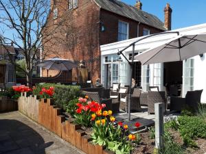 a garden with flowers and an umbrella in front of a house at Milford Hall Hotel & Spa in Salisbury