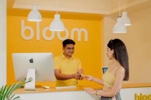 a man and a woman shaking hands in an apple store at Bloom Hotel - Sector 62 in Noida