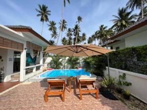 un patio con mesa y sombrilla junto a la piscina en Holiday house near Lamai with swimming pool. 2 bedrooms, en Nathon Bay
