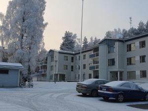 two cars parked in a parking lot in front of a building at Apartment Marja's place in Rovaniemi