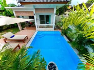 a blue swimming pool in front of a house at Holiday house near Lamai with swimming pool. 2 bedrooms in Nathon Bay