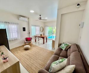 uma sala de estar com um sofá castanho e uma mesa em Holiday house near Lamai with swimming pool. 2 bedrooms em Nathon Bay