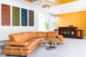 uma sala de estar com um sofá de couro e uma mesa em Hotel Latitud 15 em San Pedro Sula