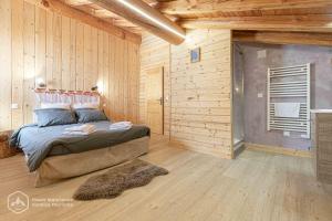 a bedroom with a bed in a wooden wall at Chalet Le Bois Joli in Bonneval-sur-Arc