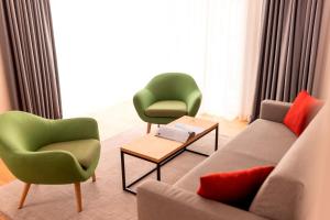 菲伯布伦All-Suite Resort Fieberbrunn inklusive Gästekarte & Lauchsee-Eintritt的有两把椅子和一张沙发的客厅 更多37张照片