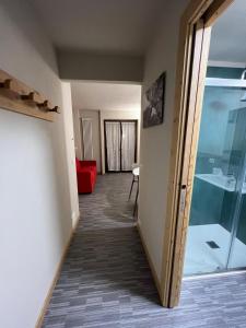 サウゼ・ドゥルクスにあるNibletの赤いソファとガラスのドアが付いた廊下