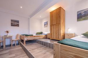 a bedroom with two beds and a wooden cabinet at Pokoje Gościnne AVA in Gliczarów