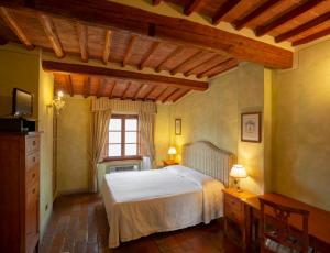 a bedroom with a white bed and a window at B&B Palazzo Al Torrione in San Gimignano