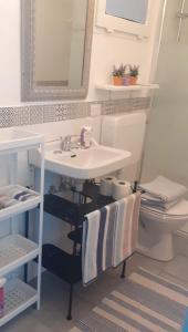 ein Badezimmer mit einem Waschbecken, einem WC und einem Spiegel in der Unterkunft B&B La Civetta in Reno Di Leggiuno