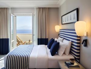 a hotel room with a bed and a large window at Summer Senses Luxury Resort in Logaras