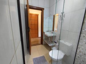 a bathroom with a toilet and a sink and a mirror at pousada canarinho in Tiradentes