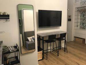 espejo en una habitación con mesa y TV en SuiteMilan133 - Navigli SantAgostino en Milán