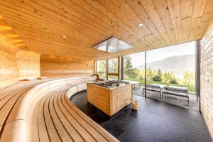 a sauna with a wooden ceiling and large windows at My Arbor - Plose Wellness Hotel in Bressanone