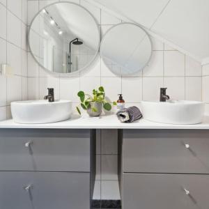 a bathroom with two sinks and two mirrors at FeelHome apartment In Tromsdalen in Tromsø