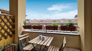 a balcony with a wooden table and chairs and plants at Branda Castiglioni 2 in Milan