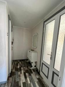 ein Badezimmer mit einem Waschbecken, einem Spiegel und einer Tür in der Unterkunft Il Ritrovo, luminoso trilocale in città in Bergamo