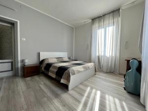 een slaapkamer met een bed en een groot raam bij Il Ritrovo, luminoso trilocale in città in Bergamo