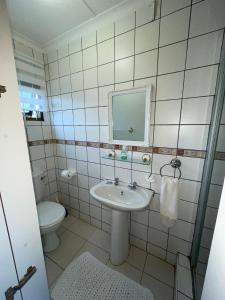 a bathroom with a sink and a toilet and a mirror at Bougainvillea BNB in Durban