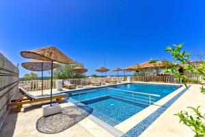 een zwembad met stoelen en parasols in een resort bij Patara Evleri in Patara