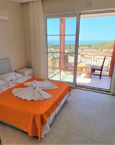 Patara Evleri في باتارا: غرفة نوم بسرير برتقالي وشرفة +98 صورة