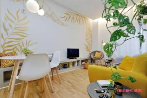 een woonkamer met gele en witte meubels en planten bij RENOVATED AND DESIGN FLAT CLOSE TO THE CENTER in Rome