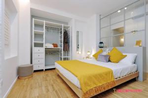 een slaapkamer met een groot bed en een gele deken bij RENOVATED AND DESIGN FLAT CLOSE TO THE CENTER in Rome