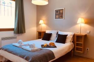 a bedroom with a bed with a tray of food on it at CHARMANT T3 AVEC VUE SUR LA MONTAGNE in Font-Romeu-Odeillo-Via