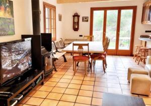 un soggiorno con TV, tavolo e sedie di Casa Donaire, alojamiento turístico a Marganell