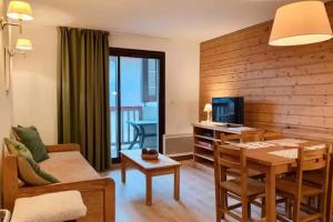 a living room with a table and a dining room at CHARMANT T3 AVEC VUE SUR LA MONTAGNE in Font-Romeu-Odeillo-Via