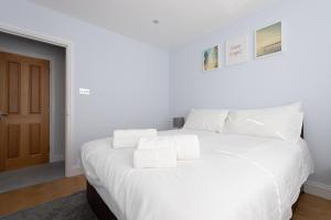 a white bed with towels on top of it at Trendy 2 Bed - A hidden Luxury in Hayes nr Heathrow in Hayes