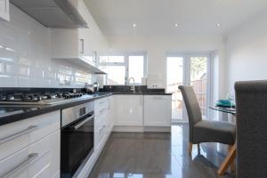 a kitchen with white cabinets and a stove top oven at Trendy 2 Bed - A hidden Luxury in Hayes nr Heathrow in Hayes