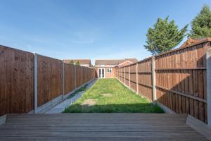 a wooden fence with a wooden walkway and a yard at Trendy 2 Bed - A hidden Luxury in Hayes nr Heathrow in Hayes