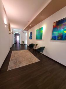 a hallway with two chairs and paintings on the wall at Palazzo Cappuccini Art Relais in Naples