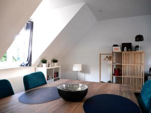 une salle à manger avec une table en bois et des chaises bleues dans l'établissement CLINT HOUSE - Appartement "Fou de Bassan", à Perros-Guirec