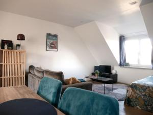 ein Wohnzimmer mit einem Sofa und einem Tisch in der Unterkunft CLINT HOUSE - Appartement "Fou de Bassan" in Perros-Guirec