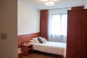 a bedroom with a white bed with a window at Zacisze in Ulan