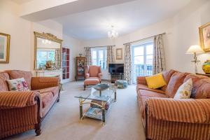 a living room with two couches and a table at 4 Ropers Court Lavenham in Sudbury
