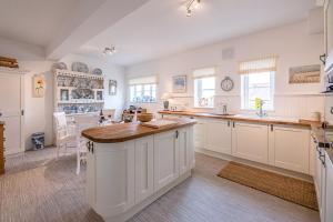 a kitchen with white cabinets and a large island at 4 Ropers Court Lavenham in Sudbury