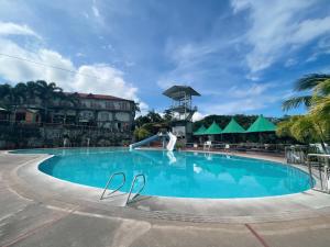 a pool at a resort with a person on a slide at La Virginia Leisure Park and Amusement powered by Cocotel in Mataasnakahoy