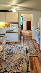 a kitchen with white cabinets and a rug at Victorian Apt at SanctuaryoftheSwan dog friendlyhotel alternative farm stay in Birdsboro