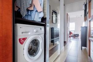 a washer and dryer in a room with a hallway at Floral Bliss Apartment in Budapest