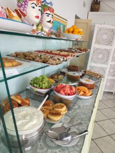 een buffet met verschillende soorten zoete deegwaren en andere voedingsmiddelen bij Hotel Ossidiana Stromboli Center in Stromboli