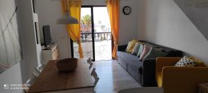 un soggiorno con divano e tavolo di Ocean and pool view - Apartamento Parque Santiago 2 ad Arona