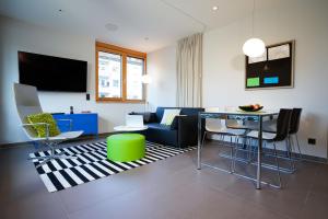 Max Lodging Serviced Apartments في ميونخ: غرفة معيشة مع أريكة وطاولة