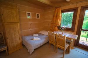 mały pokój z łóżkiem i stołem w kabinie w obiekcie Szałas pod Szymoszkową w mieście Kościelisko
